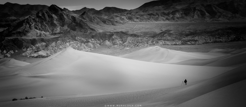 A lone photographer at Mesquite Flats Sand Dunes at Death Valley National Park in California just after sunrise